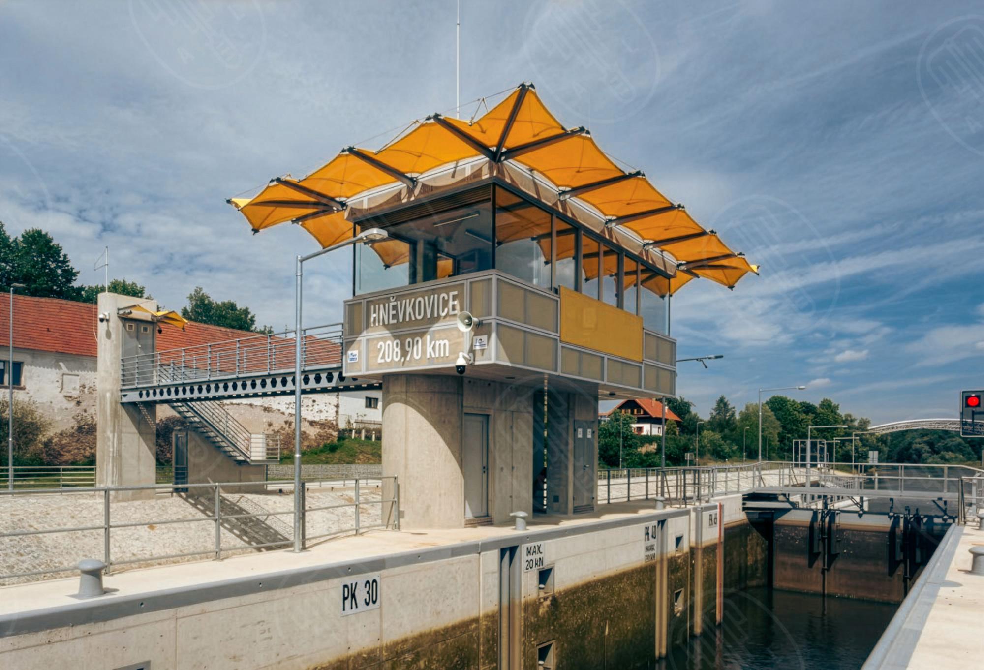 Plavební komora Hněvkovice – moderní jez s velínem od ateliéru A8000, zprovozněný roku 2017 jako součást splavnění Vltavy do Českých Budějovic. Archiv A8000. Plavební komora Hněvkovice – moderní jez s velínem od ateliéru A8000, zprovozněný roku 2017 jako součást splavnění Vltavy do Českých Budějovic. Archiv A8000.